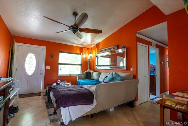 living room with a textured ceiling, vaulted ceiling, ceiling fan, and ornamental molding