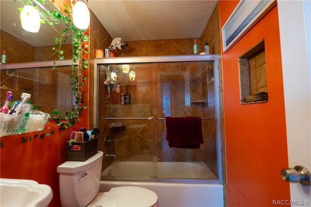 bathroom with shower / bath combination with glass door and toilet