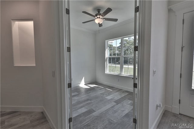 interior space with wood-type flooring, ceiling fan, and ornamental molding