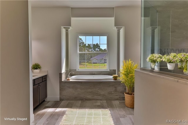 bathroom featuring vanity, decorative columns, and hardwood / wood-style flooring