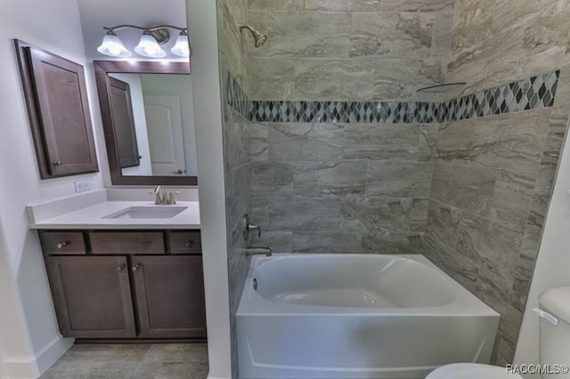 full bathroom featuring vanity, toilet, and tiled shower / bath