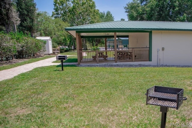 view of property's community featuring a yard and a storage shed