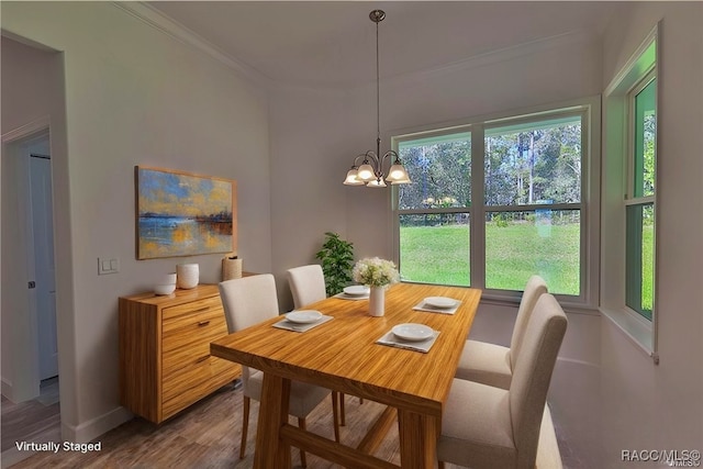 dining room with hardwood / wood-style flooring, crown molding, and a chandelier