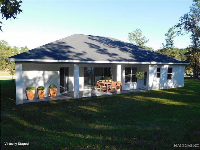 rear view of property with a yard and a patio