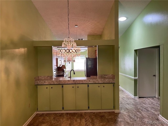 717 Whispering Pines Blvd, Inverness, FL 34453 - kitchen with freestanding refrigerator, a textured ceiling, cream cabinetry, a chandelier, and pendant lighting
