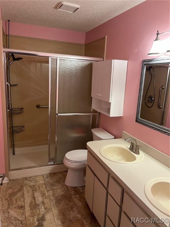 717 Whispering Pines Blvd, Inverness, FL 34453 - full bath featuring a textured ceiling, a stall shower, and double vanity