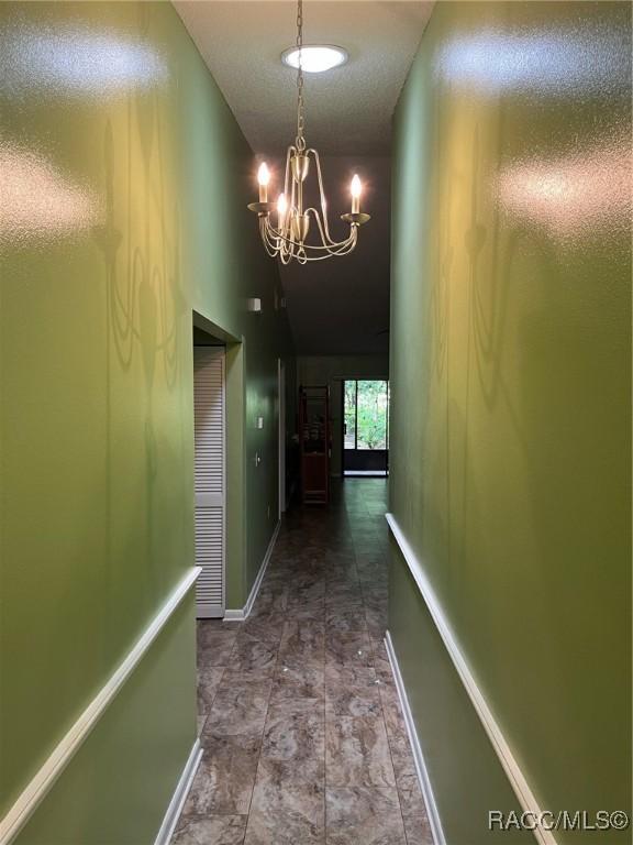 717 Whispering Pines Blvd, Inverness, FL 34453 - hall with a chandelier and baseboards