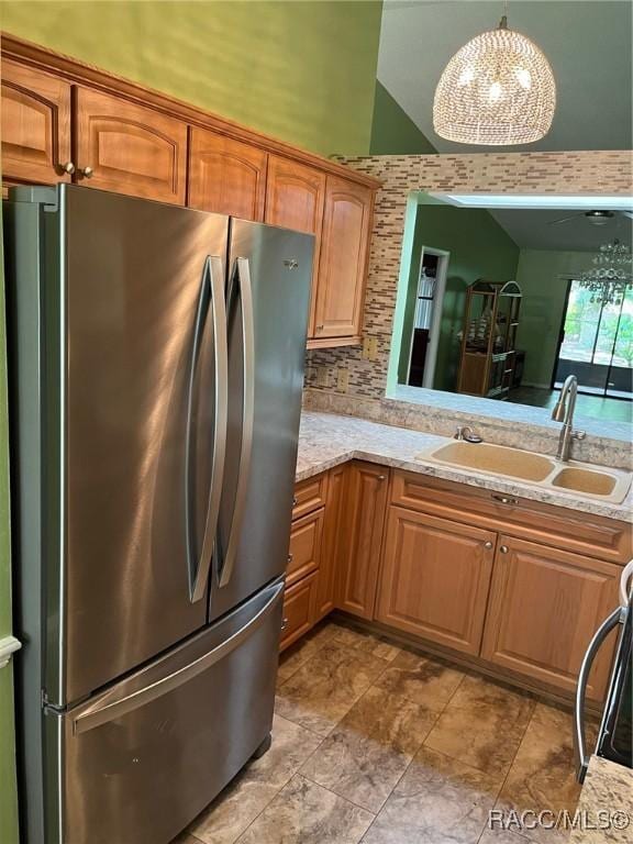 717 Whispering Pines Blvd, Inverness, FL 34453 - kitchen featuring freestanding refrigerator, a chandelier, hanging light fixtures, tasteful backsplash, and brown cabinetry