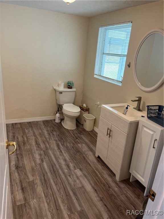 bathroom with hardwood / wood-style floors, vanity, and toilet