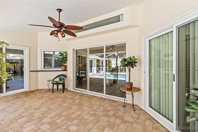 sunroom / solarium featuring ceiling fan and plenty of natural light