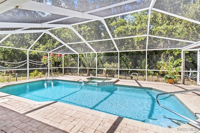 view of pool with glass enclosure, an in ground hot tub, and a patio