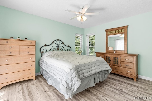 bedroom featuring ceiling fan, a textured ceiling, and light wood-type flooring