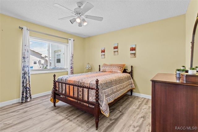 bedroom featuring a textured ceiling, light hardwood / wood-style flooring, and ceiling fan