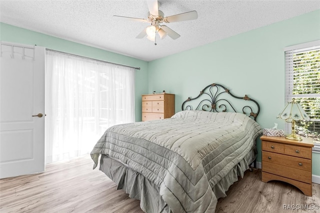 bedroom featuring a textured ceiling, light hardwood / wood-style flooring, and ceiling fan