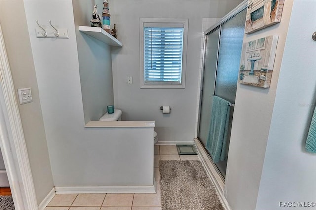 bathroom with tile patterned flooring, toilet, and walk in shower