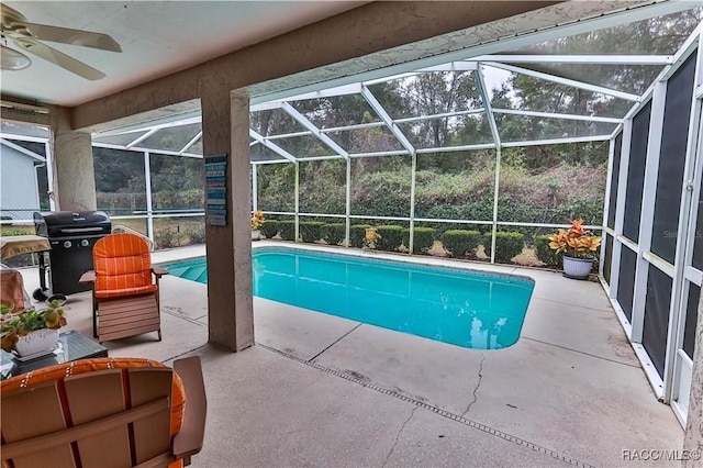 view of swimming pool with ceiling fan, area for grilling, a lanai, and a patio area