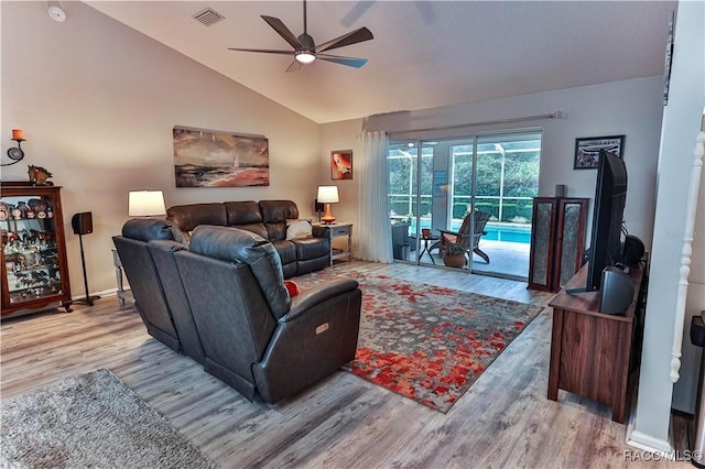 living room featuring vaulted ceiling, ceiling fan, and light wood-type flooring