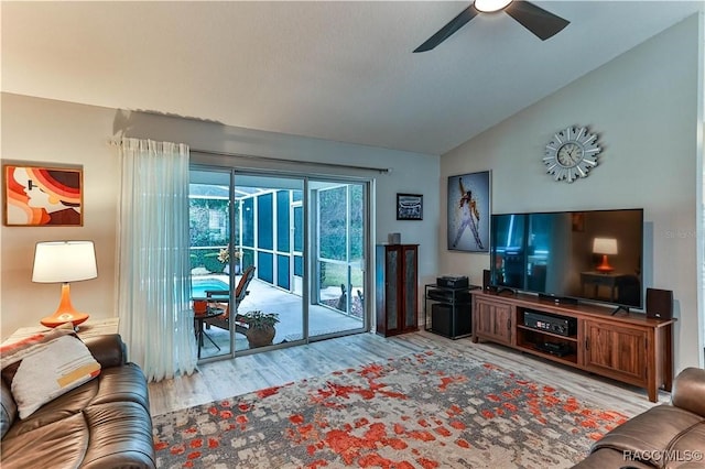 living room featuring vaulted ceiling, ceiling fan, and light wood-type flooring