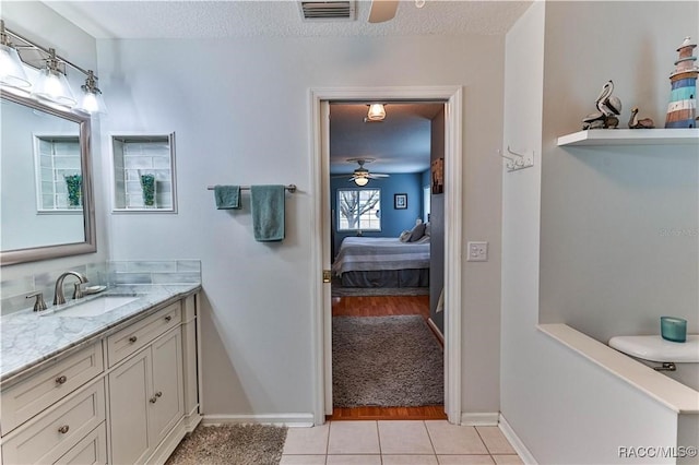 bathroom with vanity, ceiling fan, tile patterned floors, and a textured ceiling