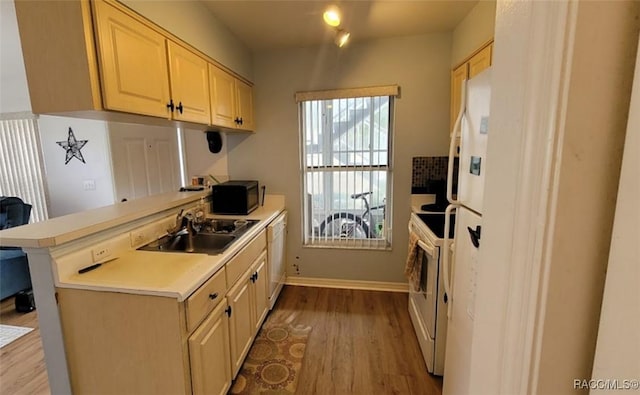 kitchen featuring kitchen peninsula, sink, white appliances, light hardwood / wood-style flooring, and light brown cabinetry