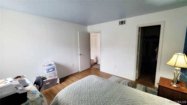 bedroom featuring a spacious closet and hardwood / wood-style floors