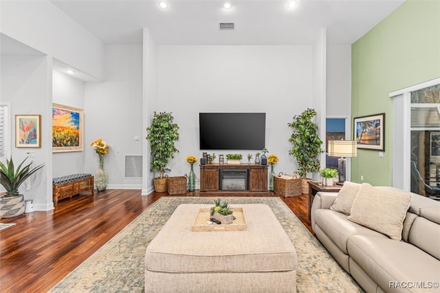 living area with baseboards, visible vents, wood finished floors, and recessed lighting