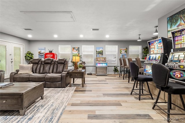 living area with attic access, recessed lighting, visible vents, and wood finished floors