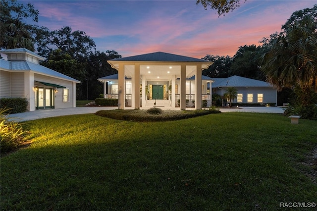 rear view of house featuring french doors and a lawn