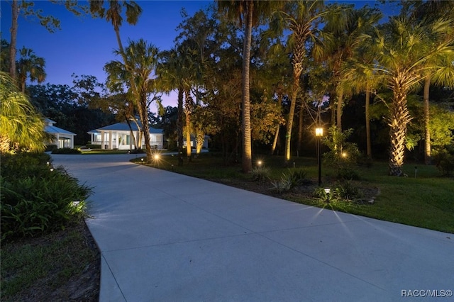 exterior space featuring concrete driveway and a front lawn