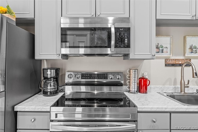 kitchen with white cabinets, stainless steel appliances, and a sink