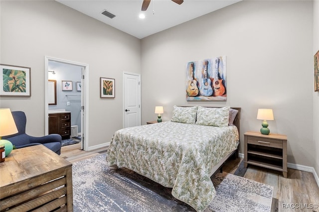 bedroom featuring light wood-style floors, baseboards, visible vents, and ensuite bathroom