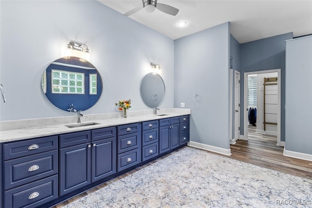 full bath with double vanity, a sink, and baseboards