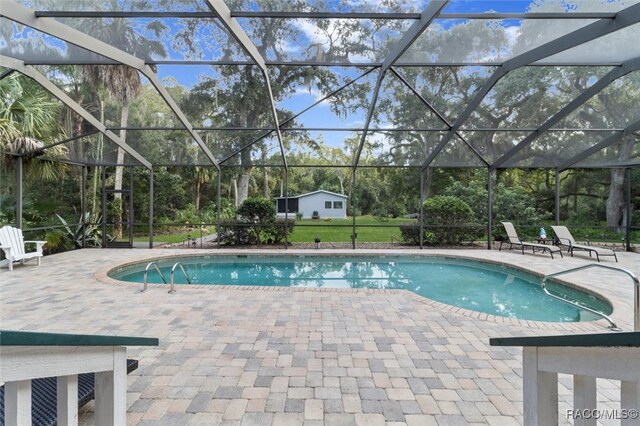 outdoor pool with a patio and a lanai