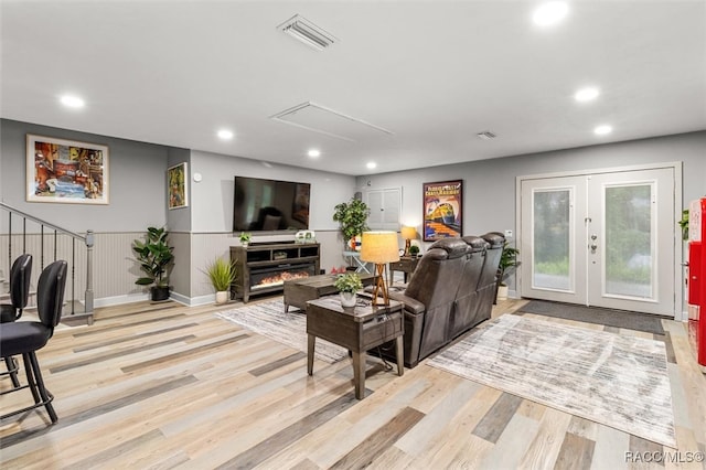 living room featuring french doors, light wood-type flooring, visible vents, and recessed lighting