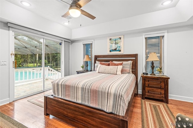 bedroom featuring access to outside, recessed lighting, wood finished floors, and baseboards