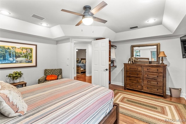 bedroom with ceiling fan, wood finished floors, and visible vents