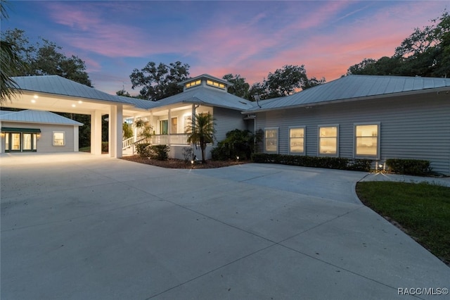 view of front facade featuring metal roof and driveway