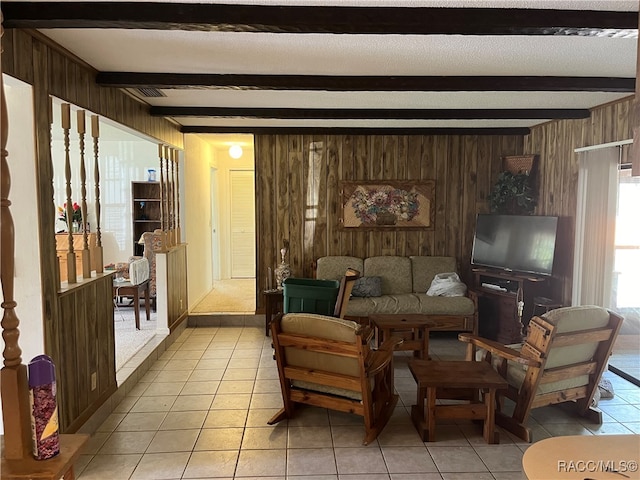 sitting room with beam ceiling, wooden walls, and light tile patterned flooring