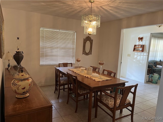 tiled dining area featuring a notable chandelier and a textured ceiling