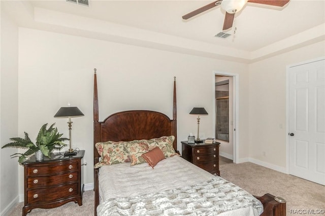 bedroom featuring ceiling fan, a raised ceiling, and light carpet