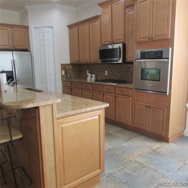 kitchen with backsplash, a kitchen breakfast bar, ornamental molding, light stone counters, and stainless steel appliances