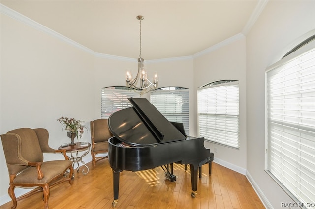 misc room with crown molding, an inviting chandelier, and light wood-type flooring