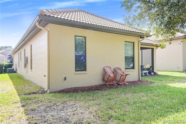 back of house featuring a yard and central air condition unit