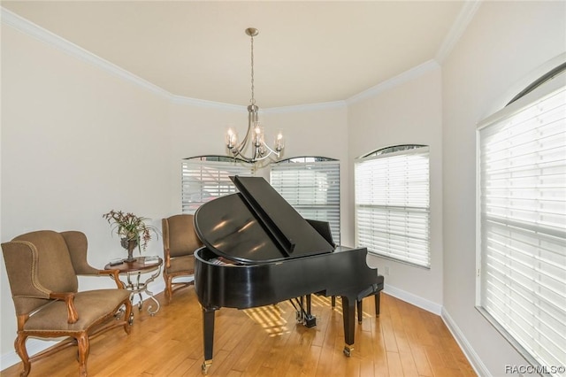 misc room with crown molding, a chandelier, and light wood-type flooring