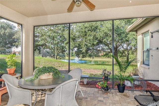 sunroom / solarium featuring a water view and ceiling fan