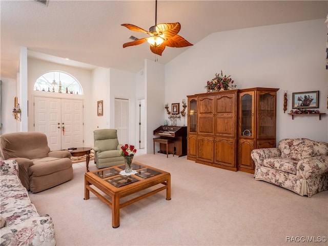 living room with ceiling fan, high vaulted ceiling, and light carpet