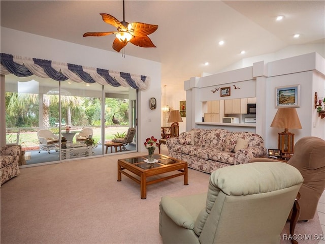 carpeted living room with ceiling fan and lofted ceiling