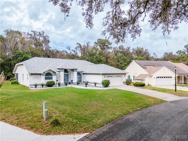 ranch-style home featuring a garage and a front lawn