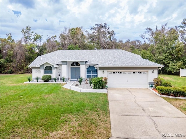 ranch-style house featuring a garage and a front lawn