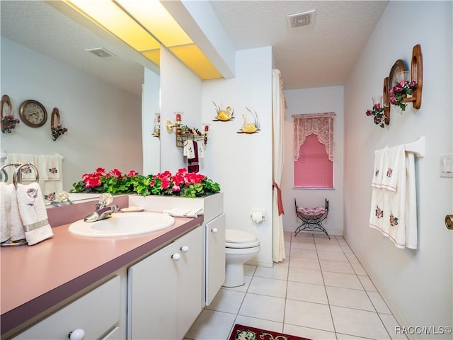 bathroom featuring a textured ceiling, toilet, tile patterned flooring, and vanity